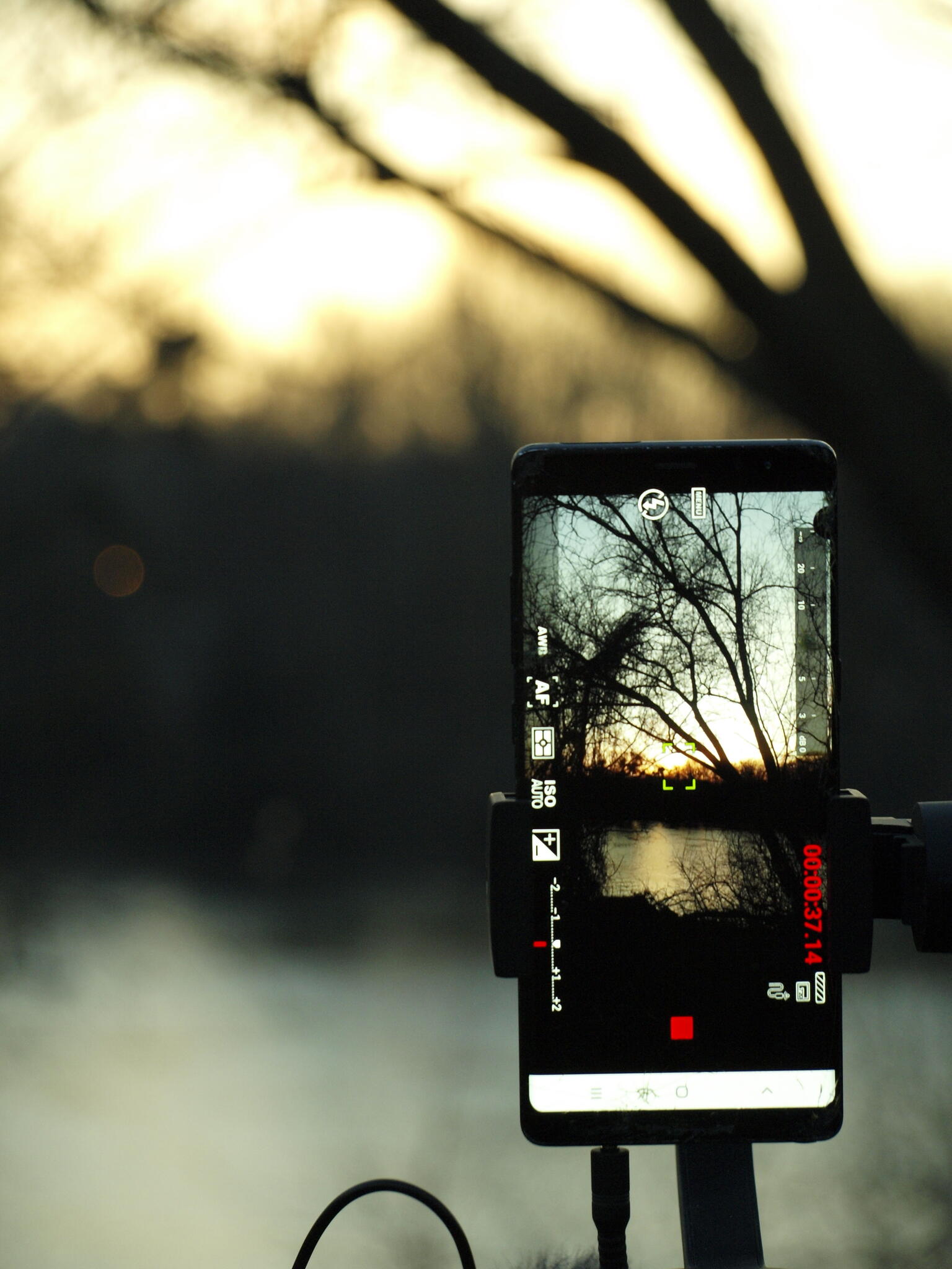 Photo représentant un téléphone qui film le paysage en pose longue au format vertical.